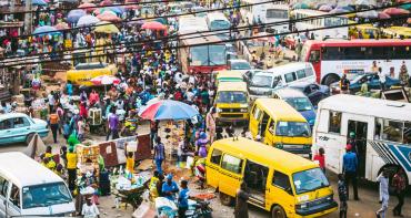 Busy market place with busses and cars