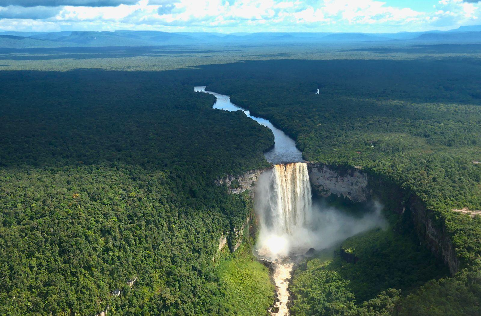 Aerial view of a waterfall surrounded by forest in Guyana