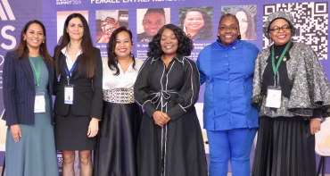 Six women sitting on a stage