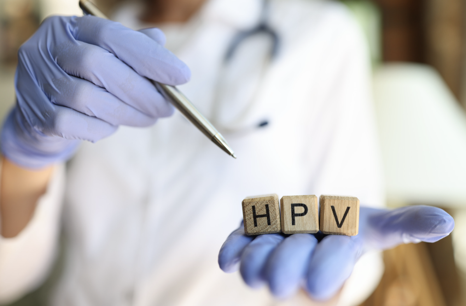 Hand with doctors gloves holding HPV wooden letters